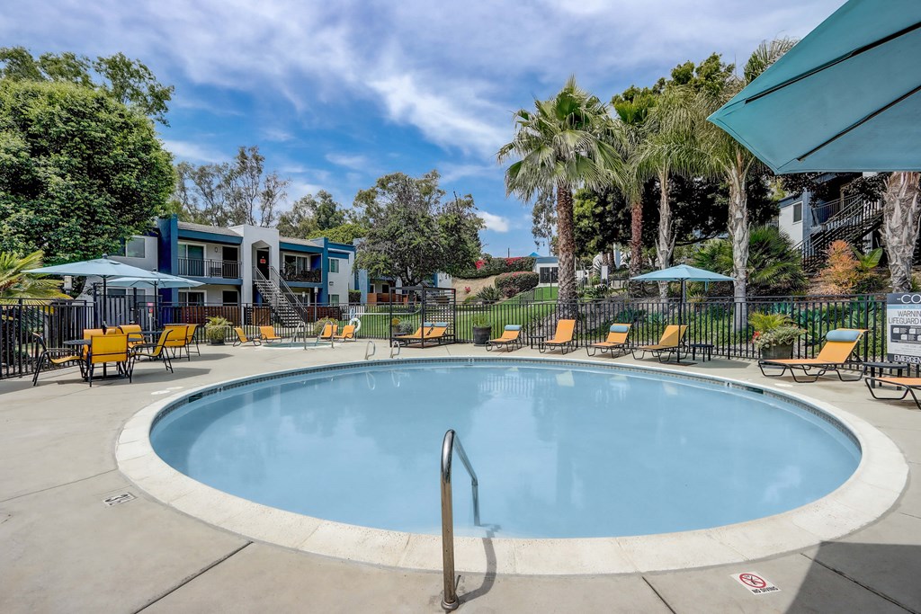 Community Swimming Pool with Pool Furniture at Cove La Mesa Apartments located in La Mesa, CA.