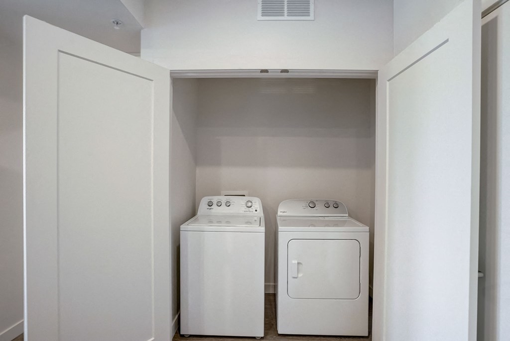 an empty laundry room with two washes and a dryer