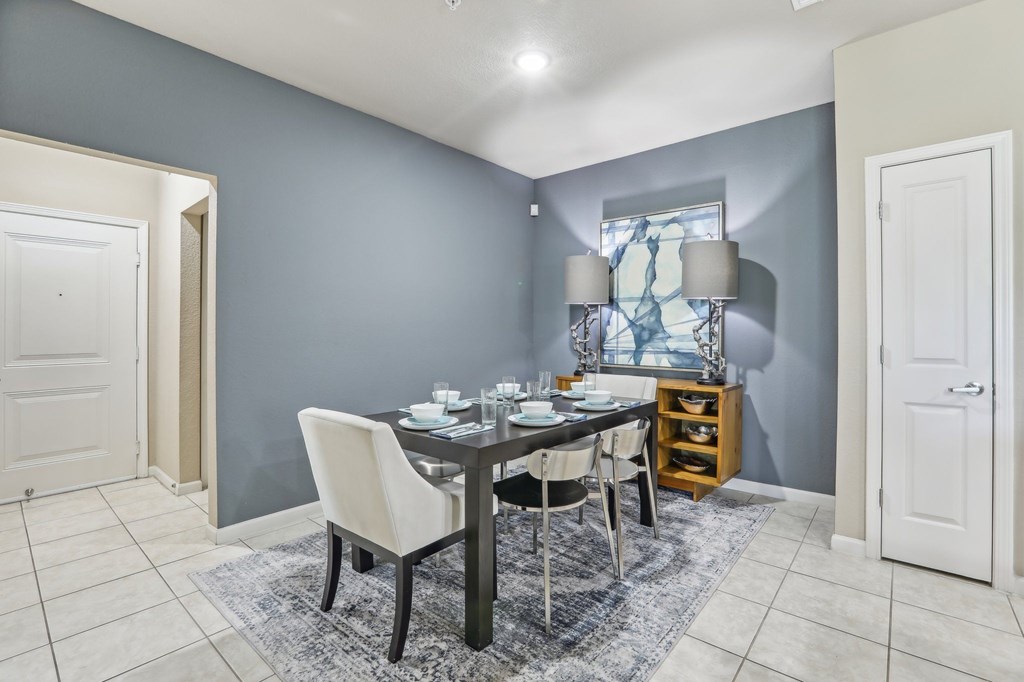 Model dining area with table near a blue wall.