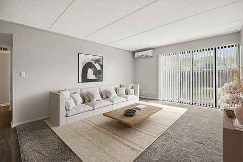 Model Living Room with Carpet and Patio Accessibility at Parkvue Flats Apartments in Burnsville, MN.