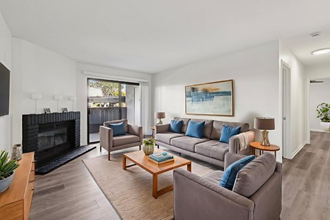 A living room with a fireplace and a painting on the wall.