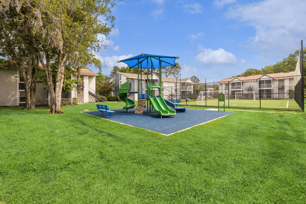Playground with sun cover at Vue at Baymeadows Apartments in Jacksonville, Florida