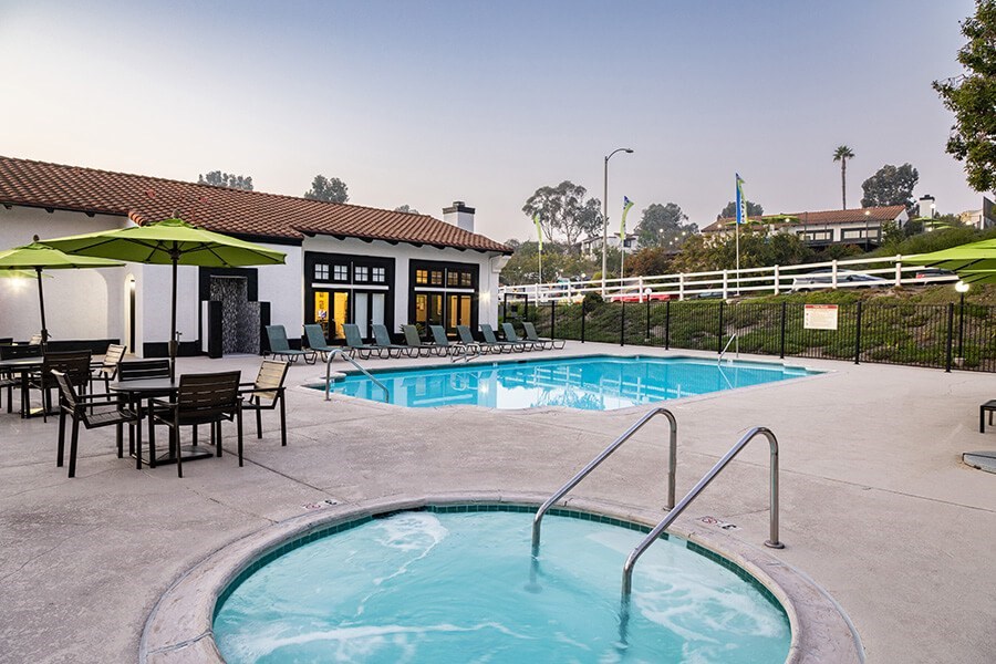 Community Swimming Pool and Hot Tub with Pool Furniture at Santa Fe Ranch Apartments located in Carlsbad, CA.