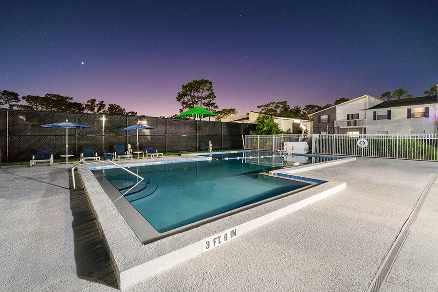 Community Swimming Pool with Pool Furniture at Arbors at Orange Park Apartments located in Orange Park, FL.