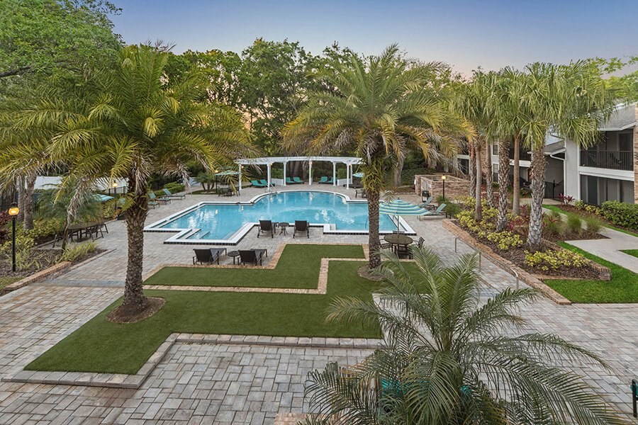 Aerial View of Community Swimming Pool with Pool Furniture at Grand Pavilion Apartments in Tampa, FL.
