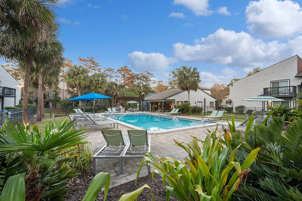 Community Swimming Pool with Pool Furniture at Heron Walk Apartments in Jacksonville, FL.