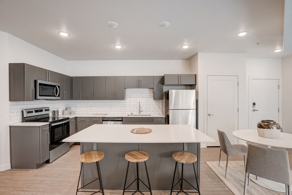 a kitchen with a white counter top and stainless steel appliances