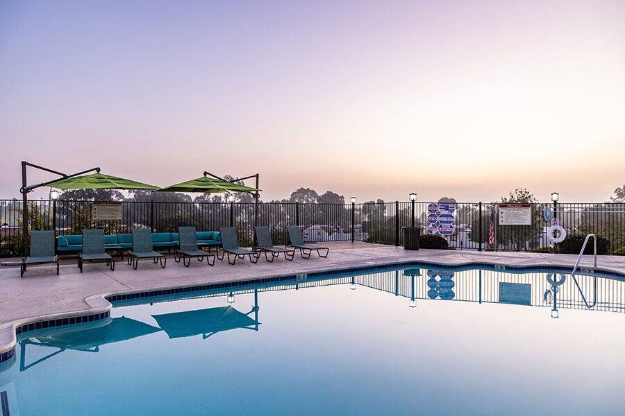 Community Swimming Pool with Pool Furniture at Santa Fe Ranch Apartments located in Carlsbad, CA.