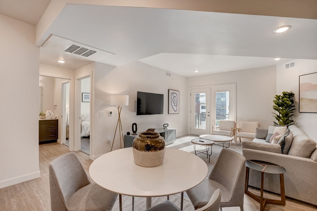 a living room with a round table and chairs and a couch