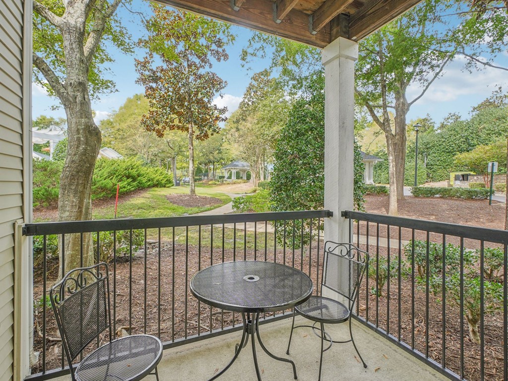 A patio with a table and chairs overlooking a garden.