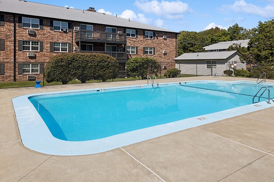 Community Swimming Pool with Pool Furniture at Middlesex Crossing Apartments located in Billerica, MA.