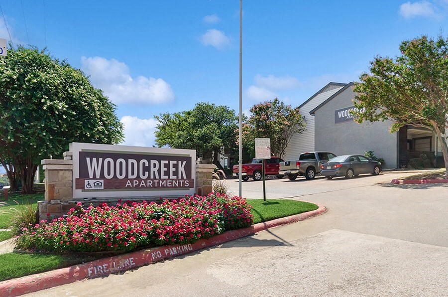 Community Monument Sign and Landscape at Woodcreek Apartments located in Arlington, TX.