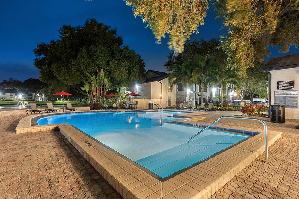 Community Swimming Pool with Pool Furniture at Carrollwood Station Apartments in Tampa, FL.