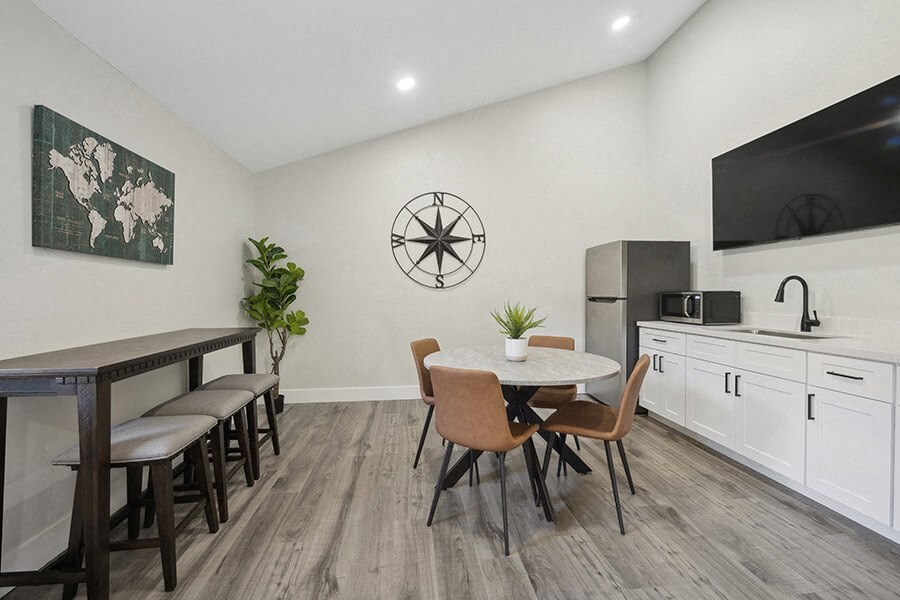 Community Clubhouse with Kitchenette Area and TV at Villages at Metro Center Apartment located in Phoenix, AZ.