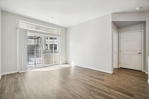 Model Living Room with Wood-Style Flooring and Patio Accessibility at Altitude on Fifth Apartments located in Salt Lake City, UT.