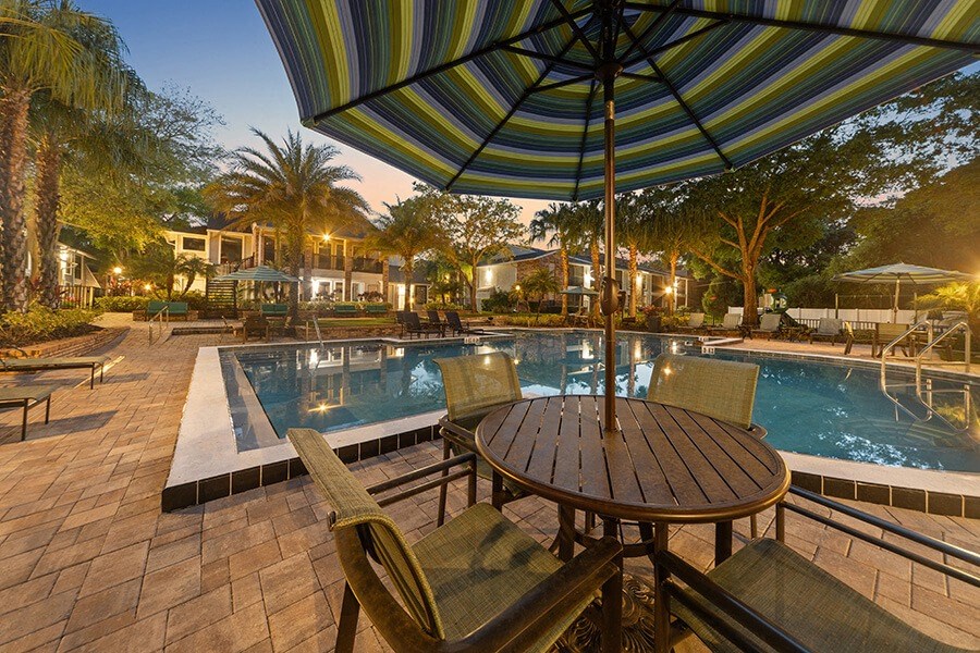Community Swimming Pool with Pool Furniture at Grand Pavilion Apartments in Tampa, FL.