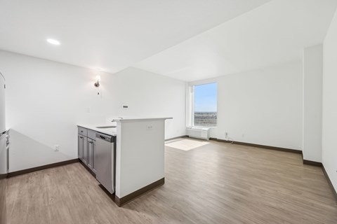 A kitchen with white cabinets and a wooden floor.