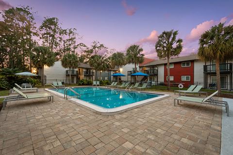 Community Swimming Pool with Pool Furniture at Heron Walk Apartments in Jacksonville, FL.