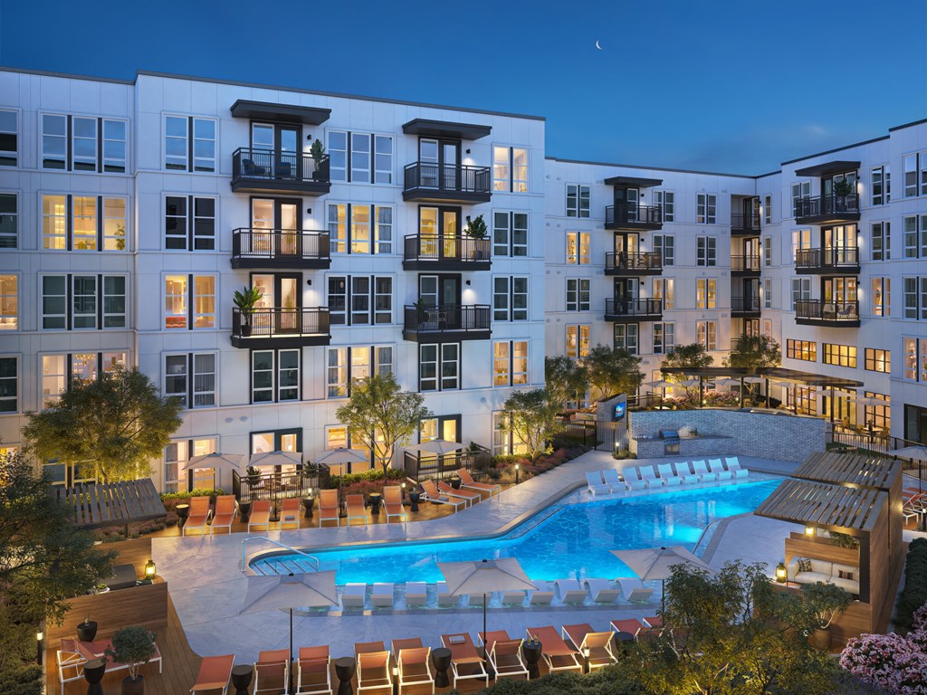 an apartment building with a swimming pool at night