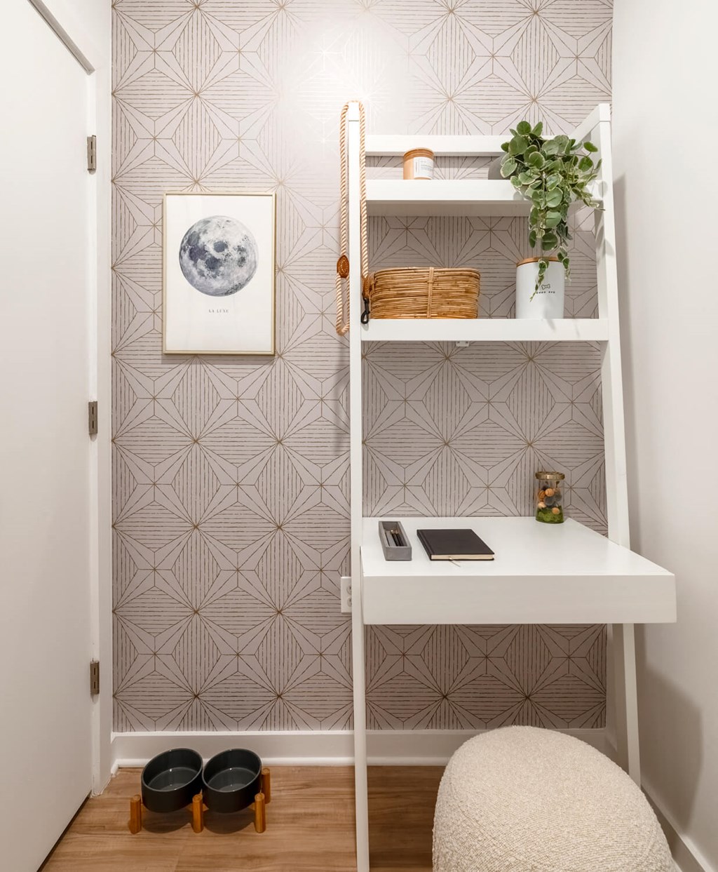 a small workspace with a white desk and a white shelf and a chair