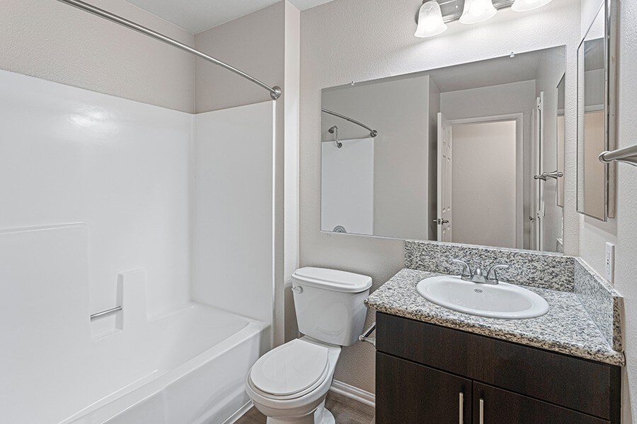 Model Bathroom with Dark Wood Cabinets and Shower/Tub at Santa Fe Ranch Apartments located in Carlsbad, CA.