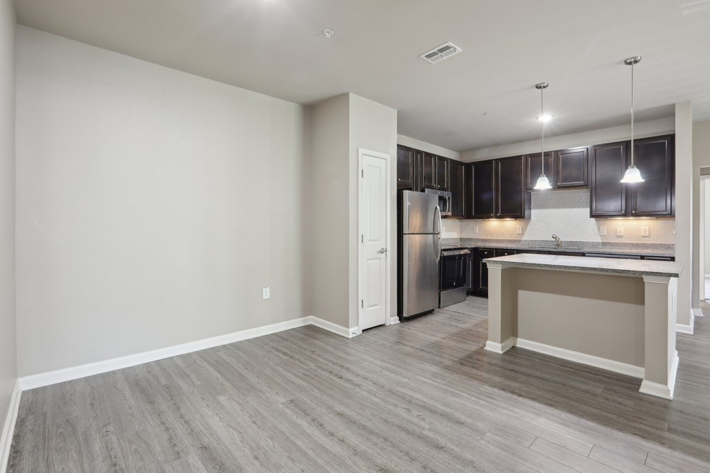 Model kitchen with a refrigerator, cabinets, and a countertop.