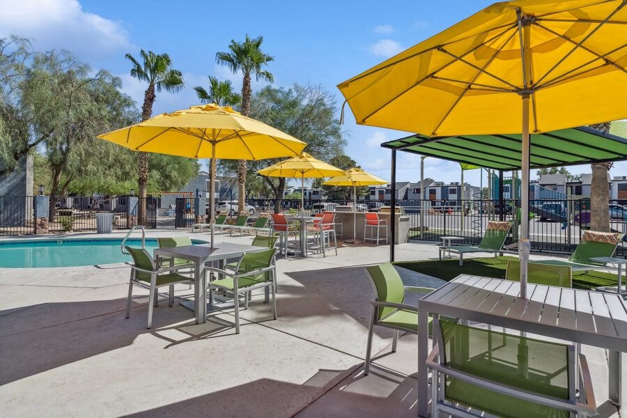 the pool at our apartments has tables and chairs with umbrellas