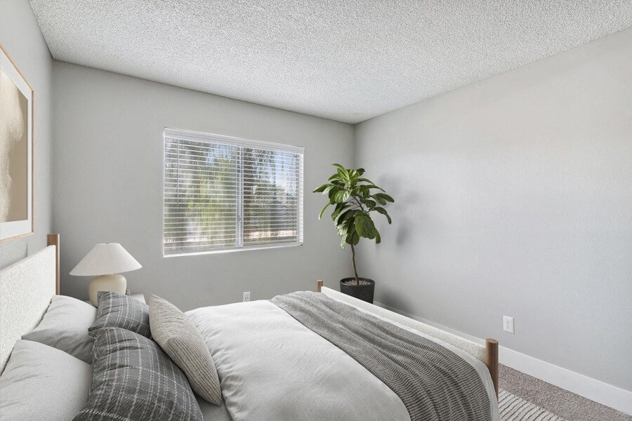 an empty bedroom with a bed and a window
