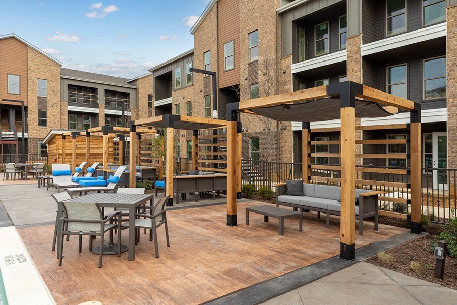 Outdoor lounge space with covered seating at Alta 3Eighty Apartments in Aubrey, TX