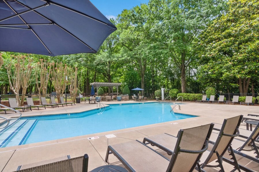 a swimming pool with chaise lounge chairs and umbrellas