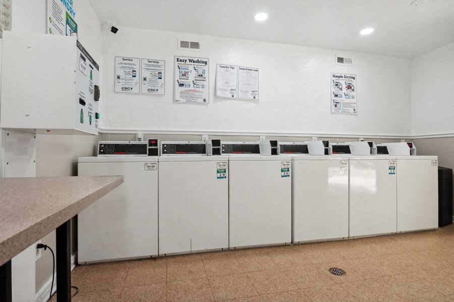 a laundry room with many washers and dryers