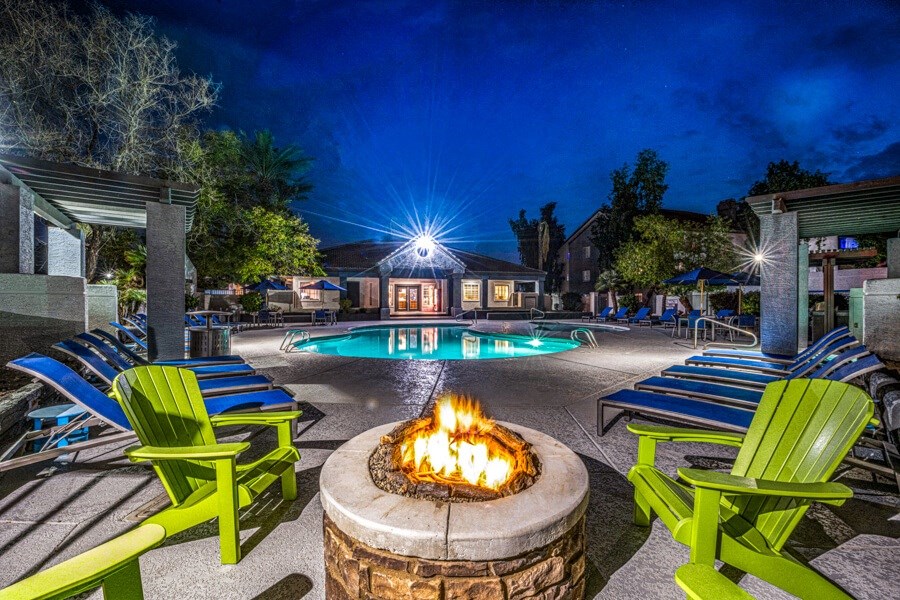 a fire pit and pool at night at the resort at turf