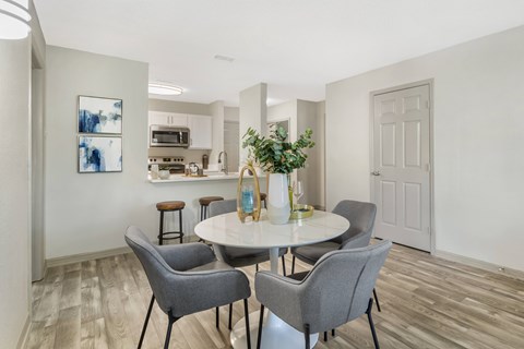 A dining room with a table and chairs.