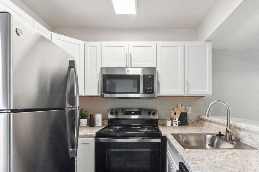 a kitchen with a stove top oven by a refrigerator