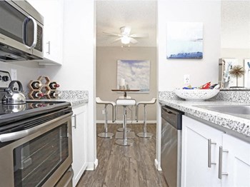 Kitchen with stove, sink, granite counter tops, dishwasher, and microwave. - Photo Gallery 6