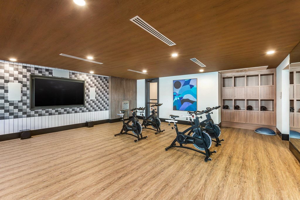 a gym with exercise machines and a tv on the wall