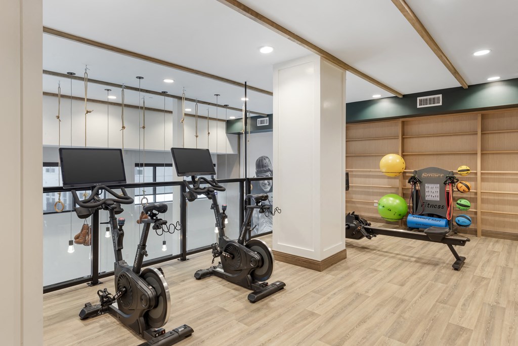 a gym with treadmills and weights on a wooden floor