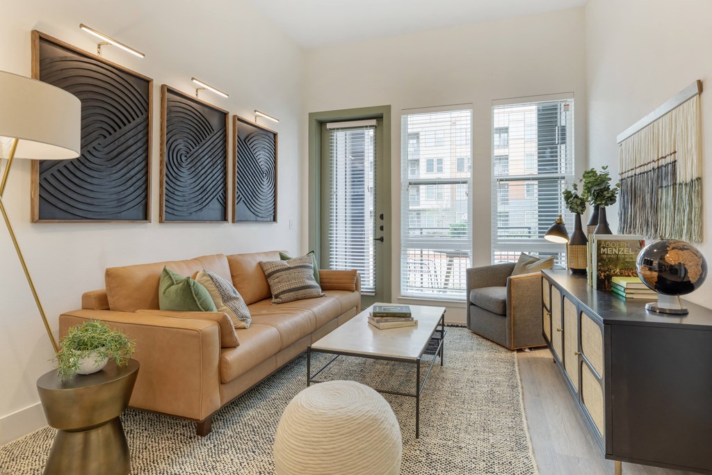 a living room with a couch and a coffee table    and three paintings