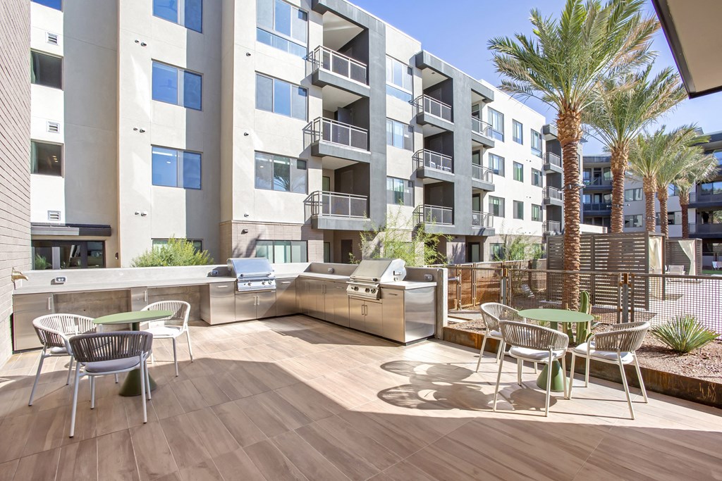 an outdoor patio with tables and chairs and an apartment building