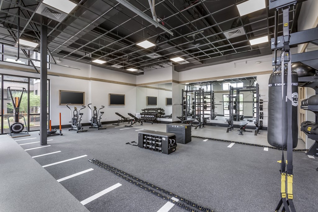 a gym with weights machines and other equipment on the floor and a wall mounted tv