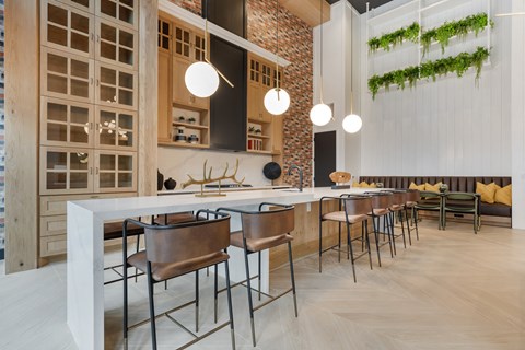 a kitchen with a long counter and chairs in a restaurant