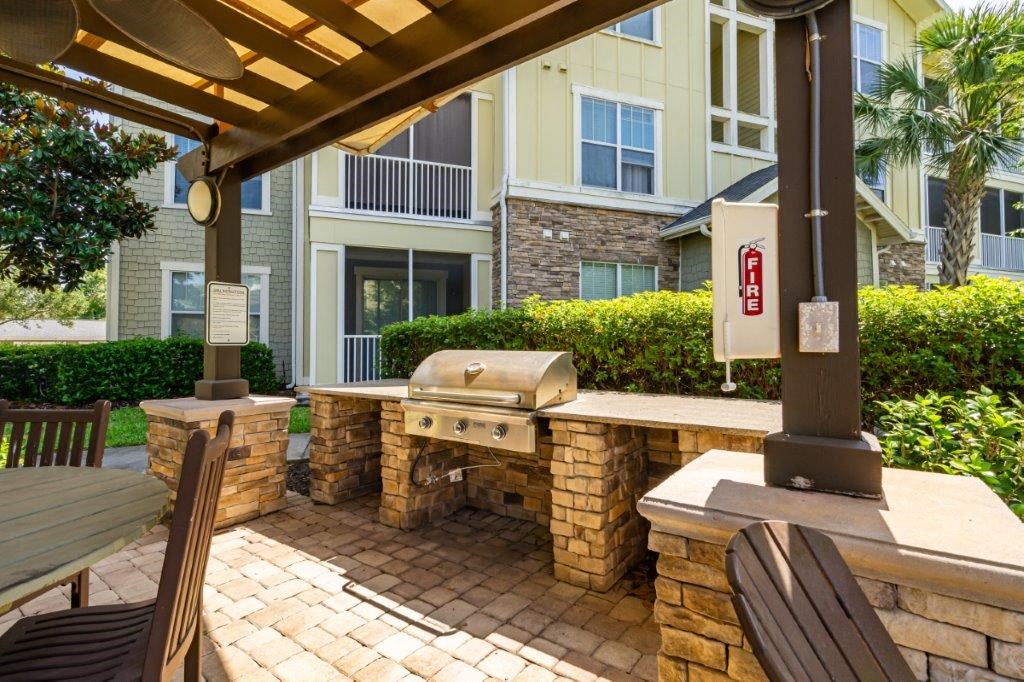 A patio with a grill and chairs at Bridges at Crosstown in Tampa, FL