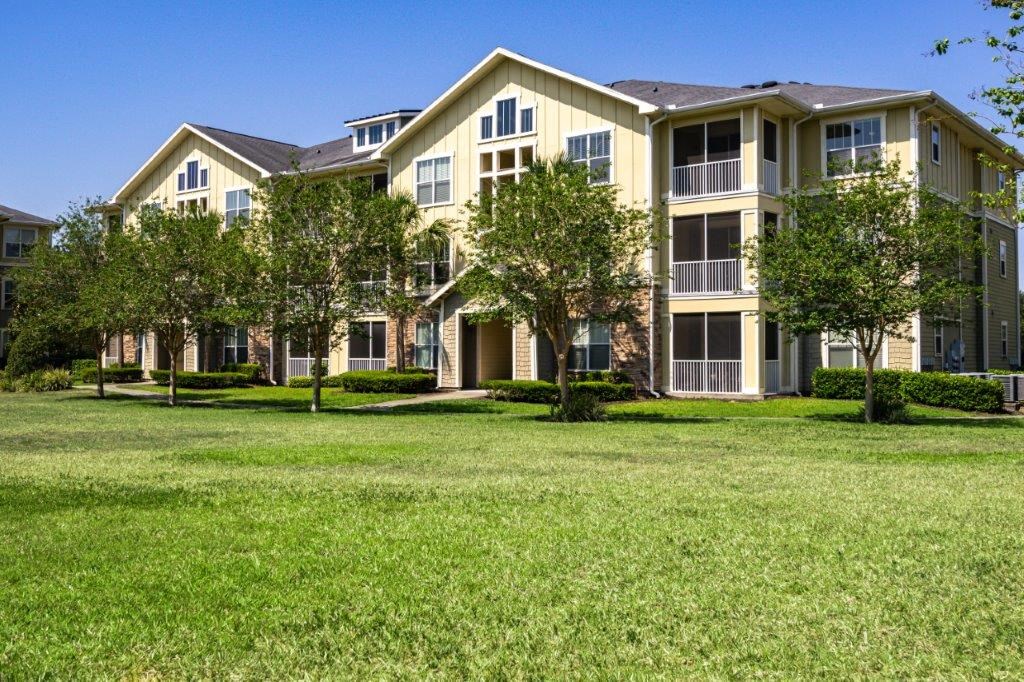 Apartment building exterior with a green lawn in front at Bridges at Crosstown in Tampa, FL