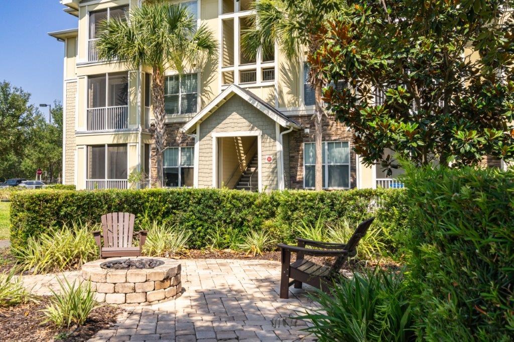 Apartment building with a balcony and a fire pit in front at Bridges at Crosstown in Tampa, FL