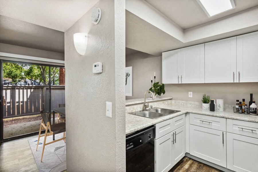 a kitchen with white cabinets and a black dishwasher