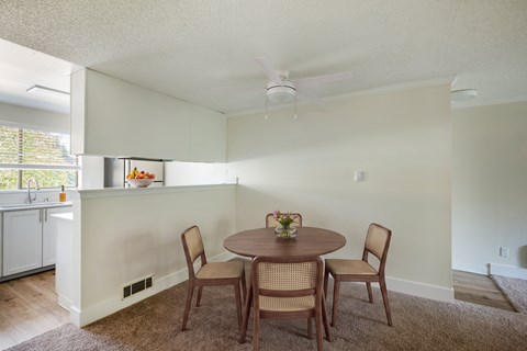 A dining room with a round table and chairs.