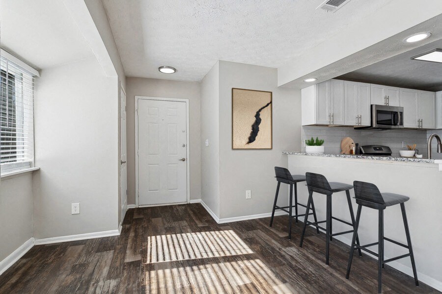 Open kitchen and living room with a breakfast bar and stools