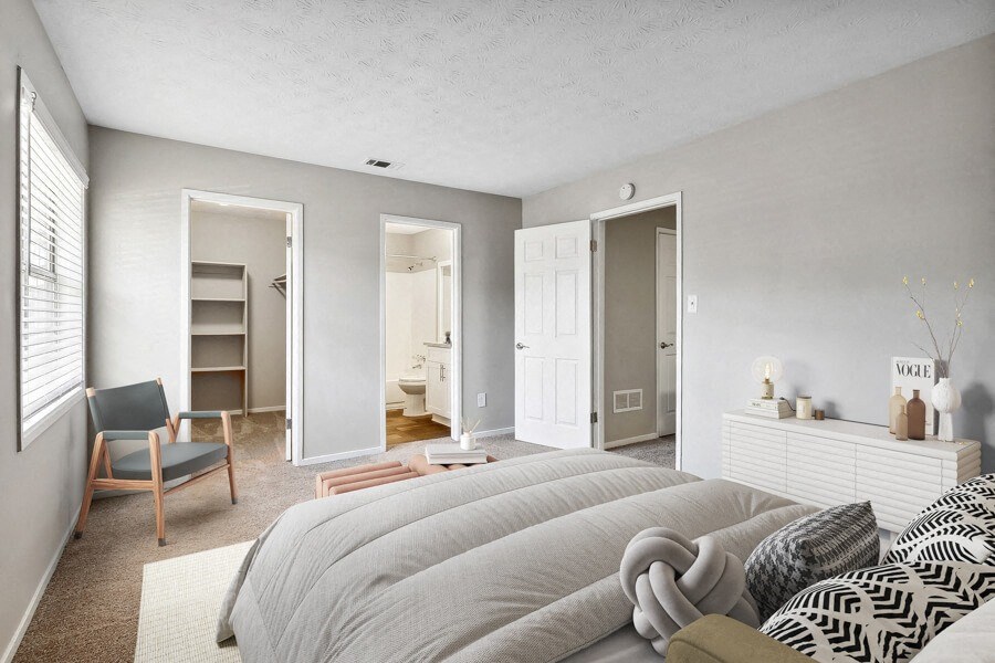 Model apartment bedroom with a large bed and a closet