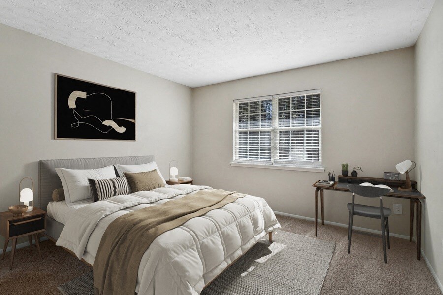 Model apartment bedroom with a bed and a desk and a window