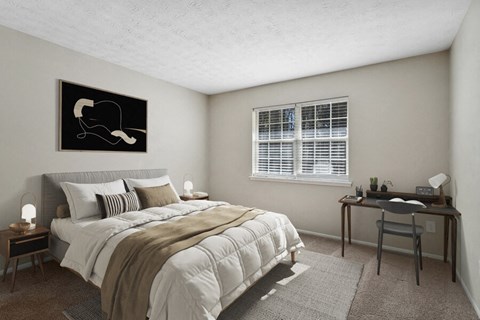 Model apartment bedroom with a bed and a desk and a window